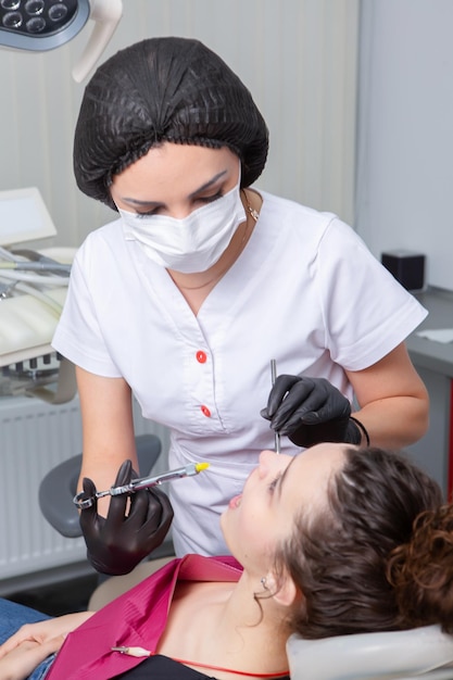 Dentista que examina los dientes de los pacientes en la clínica dental Odontología y atención médica