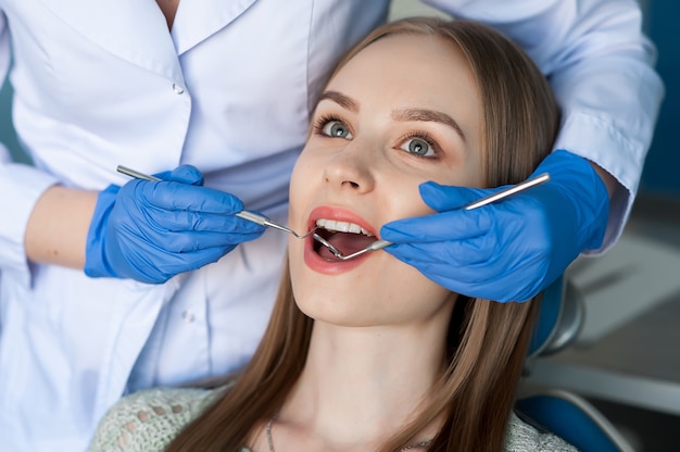 Dentista que examina os dentes de um paciente no dentista.