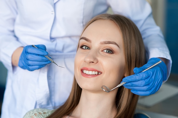 Dentista que examina os dentes de um paciente no dentista.