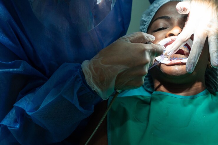 Foto dentista que realiza el procedimiento de tratamiento dental en la clínica dental