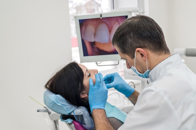 Dentista que trabaja con el paciente en el consultorio del dentista