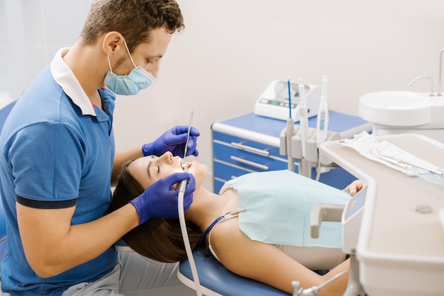 Un dentista que trabaja con un paciente con taladro dental