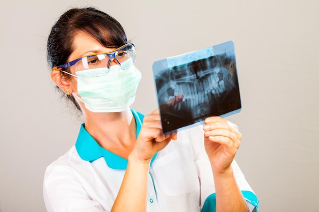 Dentista con rayos x sobre fondo gris