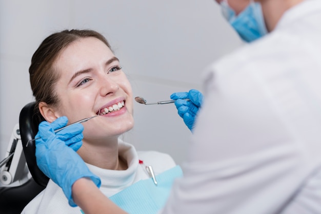 Dentista, realizando verificação dentária no paciente