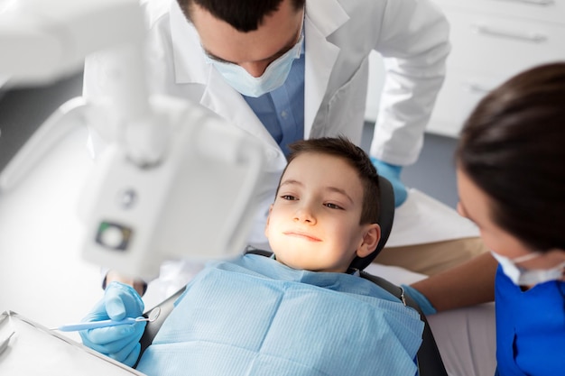 dentista revisando los dientes de los niños en la clínica dental