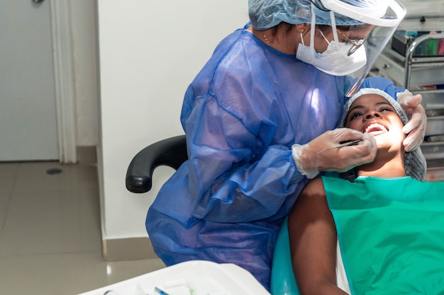 Dentista revisando los dientes del paciente en el consultorio del dentista