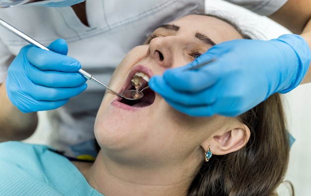 Dentista revisando los dientes del paciente con espejo en odontología