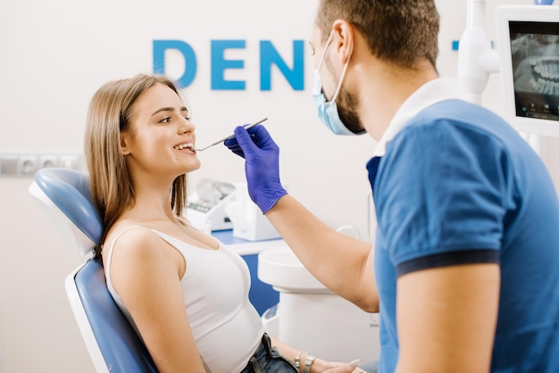 Dentista revisando los dientes de los pacientes con instrumentos