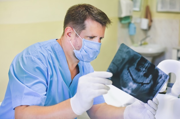 Dentista, segurando uma imagem de um raio-x nas mãos