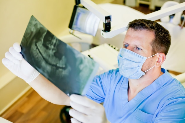 Dentista, segurando uma imagem de um raio-x nas mãos