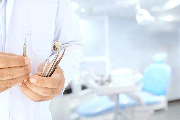 Dentista segurar ferramentas na mão, prepare-se para trabalhar na sala.