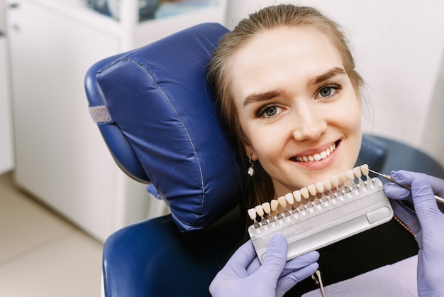 El dentista selecciona el color del esmalte de los dientes.