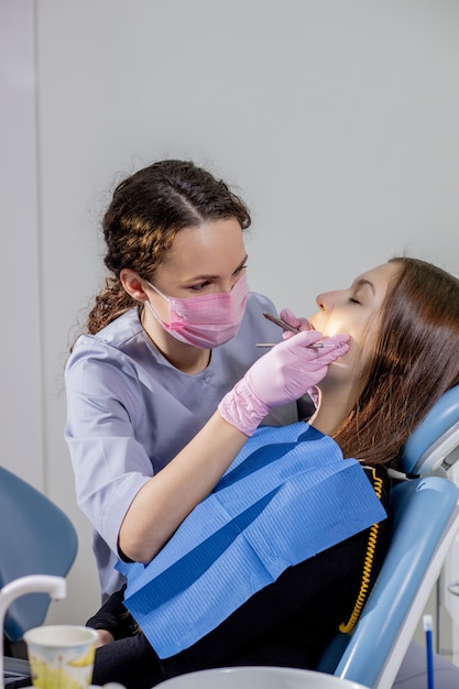 Foto dentista de sexo femenino que controla los dientes del paciente en la oficina de la clínica dental. medicina, concepto de odontología. equipo dental