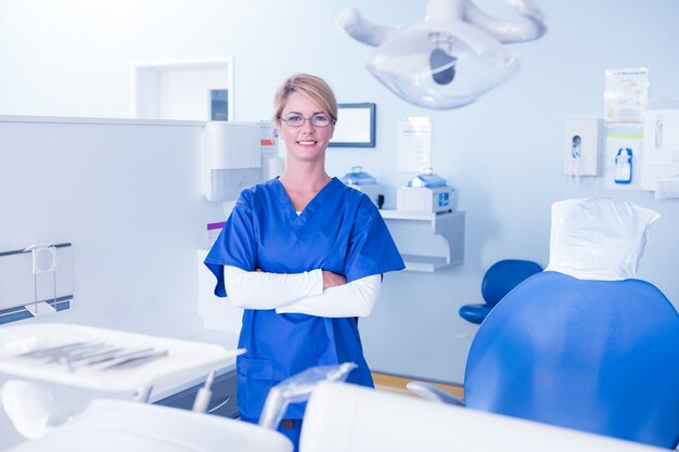 Dentista sorrindo na câmera com os braços cruzados