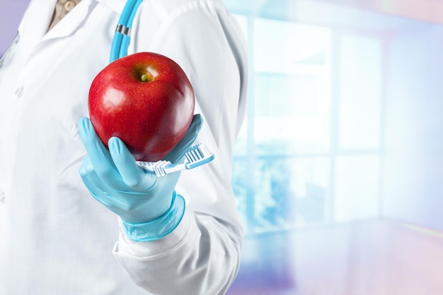 Dentista sosteniendo una manzana madura