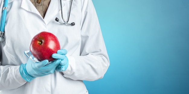 Dentista sosteniendo una manzana madura