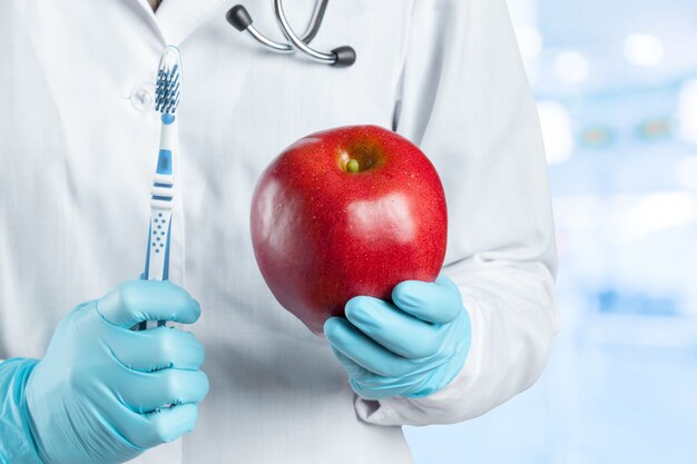 Dentista sosteniendo una manzana madura