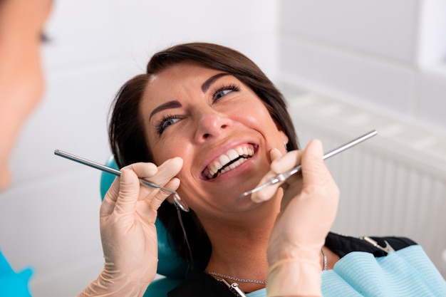 Foto un dentista termina una restauración dental exitosa, un médico aconseja a un paciente feliz