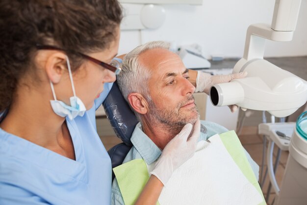 Foto dentista tomando um raio x de boca de pacientes