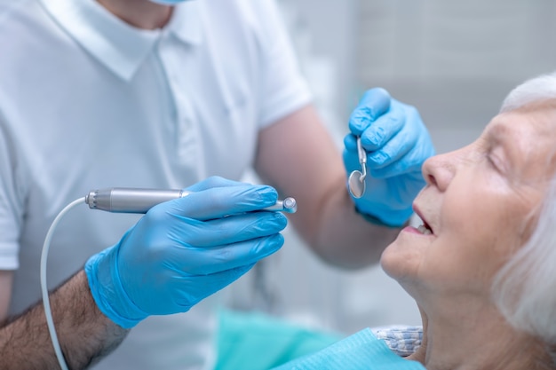 Dentista en el trabajo. Dentista en guantes estériles trabajando con un paciente en su oficina