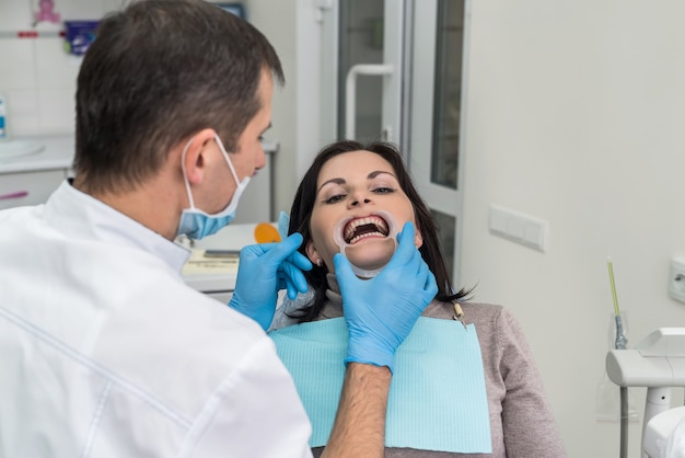 Dentista trabalhando com paciente em consultório dentário