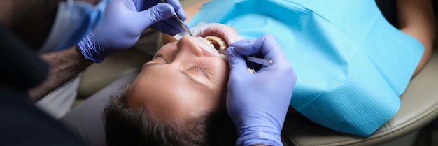 Dentista trata dentes com cárie para paciente do sexo feminino na clínica odontológica