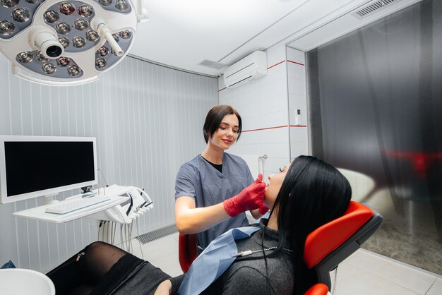 El dentista trata los dientes de la niña al paciente. Odontología