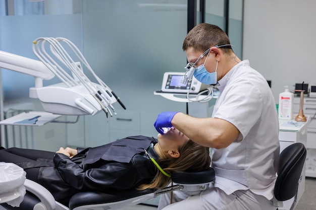 Un dentista trata los dientes de un paciente Odontología progresiva moderna Consultorio dental con herramientas