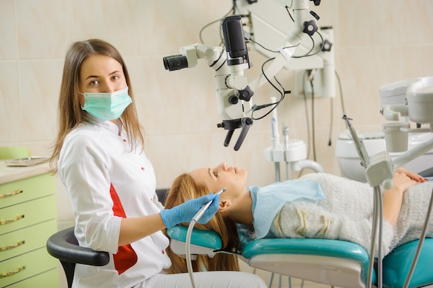 Dentista, tratando cárie usando microscópio no hospital