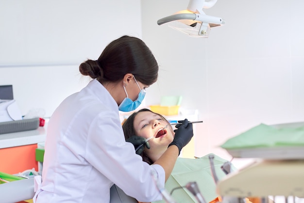 Dentista tratando los dientes a un paciente en la clínica dental