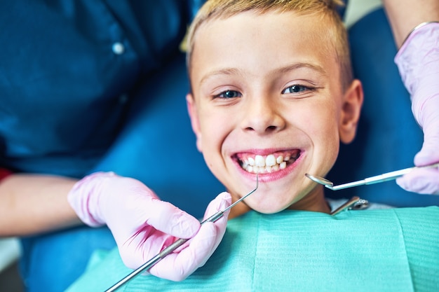 Dentista tratando sus dientes y llenando la cavidad en la clínica moderna