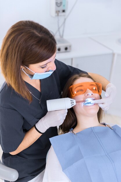 Dentista, usando, clarear, laser, ligado, femininas, paciente