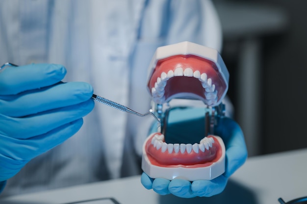 Foto un dentista está usando equipos dentales especializados para inspeccionar las dentaduras dentales para estudiar la anatomía de los dientes antes de usar el conocimiento para tratar a los pacientes las dentaduras están siendo estudiadas por especialistas orales