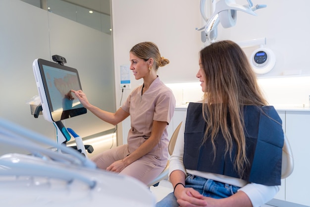 Dentista usando tecnologia moderna para explicar um procedimento odontológico a um paciente