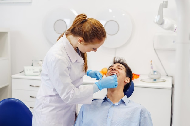 Dentista verificando os dentes do jovem