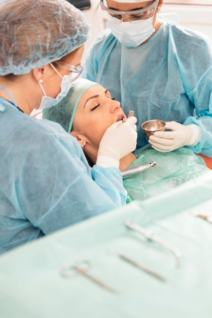 Dentistas com um paciente durante uma intervenção odontológica.