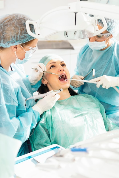 Dentistas com um paciente durante uma intervenção odontológica.