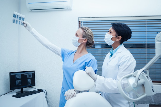 Dentistas concentrados mirando rayos x