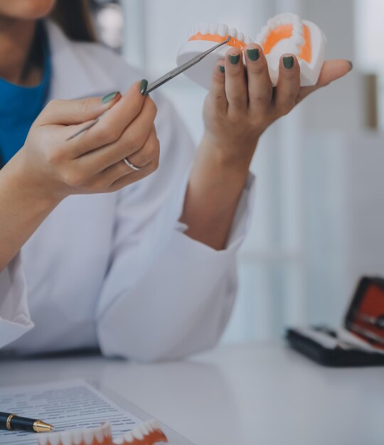 Foto los dentistas están discutiendo problemas dentales en el informe de la imagen de rayos x en la pantalla del portátil a los pacientes