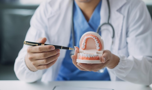 Dentistas estão discutindo problemas dentários na imagem de raio-x do relatório na tela do laptop para pacientes