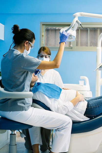 Dentistas examinando a una mujer embarazada en la clínica
