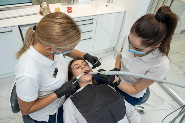 Las dentistas tratan los dientes de una paciente joven con el último equipo