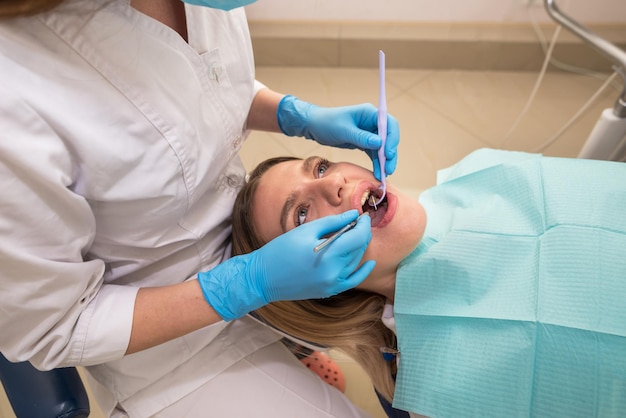 Dentisthygienist realiza un procedimiento de limpieza de dientes para una niña en una clínica dental Eliminación de sarro El concepto de tratamiento dental de odontología