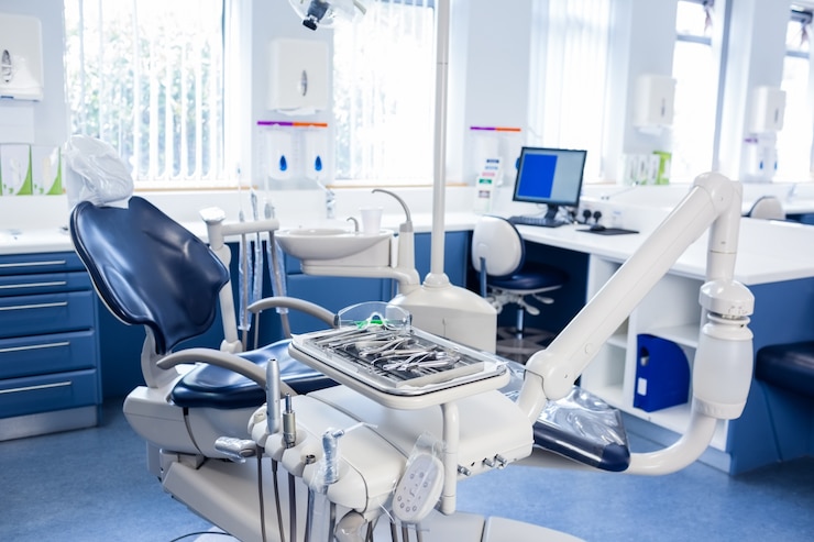 Foto dentro de la clínica con sillas de dentistas, computadora y herramientas