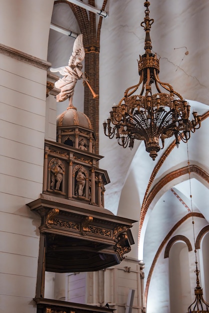 Dentro de uma igreja gótica, vista do púlpito e do candelabro na Letônia