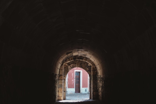 Dentro de un túnel de piedra con un edificio en el fondo en Portugal