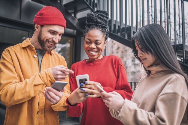 Dependencia de Internet. Tres amigos que pasan tiempo juntos en línea y lucen emocionados