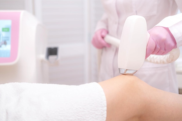 Depilação a laser de diodo Esteticista remove pêlos em belas pernas femininas Depilação para procedimento a laser de pele lisa no estúdio de beleza ou clínica Tratamento de depilação de cuidados com o corpo