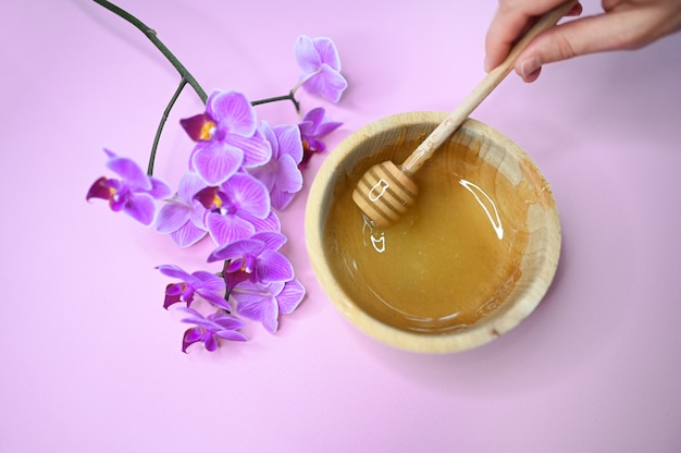 Depilação depilação colar derretido, orquídea e mão feminina