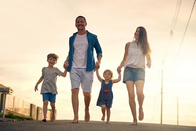 Depois do jantar, adoramos passear juntos Foto de uma jovem família passeando pela estrada lá fora